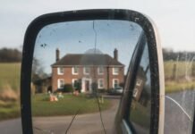 Inside the Glam Life: 10 Celebrities Who Live Modestly Cracked truck mirror reflects mansion, smudged fingerprint.