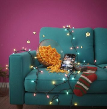Top 20 TV Shows Everyone’s Talking About in 2025 Couch with Cheetos, iPhone, Christmas lights, and a sock.