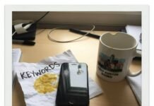 New Releases Round-Up: What Everyone’s Watching This Week Polaroid: desk, keyword printout, iPhone, mug.