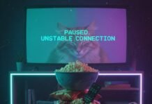 The Ultimate List: 25 Must-Watch Shows Across All Platforms Snacks, paused streaming, sleepy cat, VHS grain, neon light.